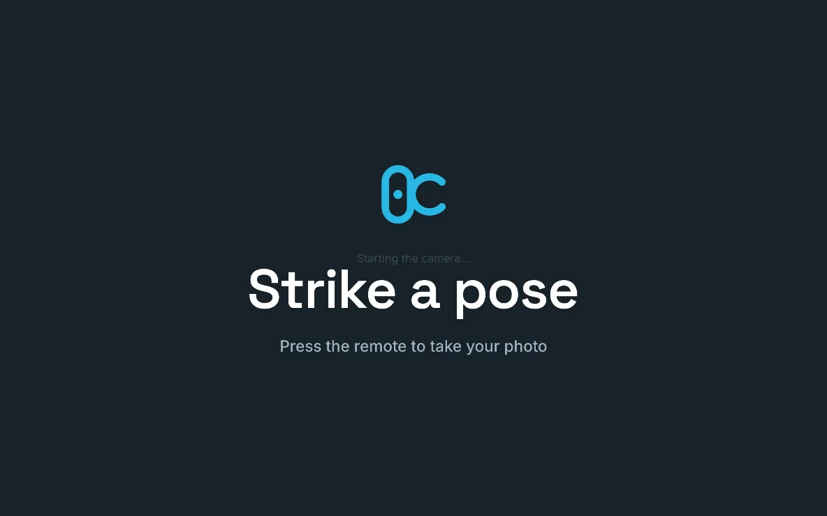The attract screen: the ZeroCapture logo, “Strike a pose” and “Press the remote to take your photo”, on a large screen in landscape.